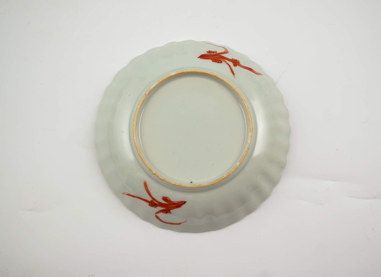 A Chinese rouge de fer tea bowl and saucer and a similar cup, Qianlong period